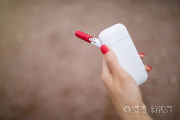 照片 手持电子香烟的妇女特写.美丽的女孩使用电子香烟.