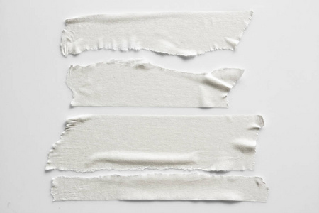 一组灰色背景的白色透明胶带。撕裂水平和不同尺寸的白色粘胶带, 粘合件