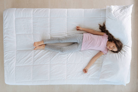 可爱的小女孩睡在床上照片