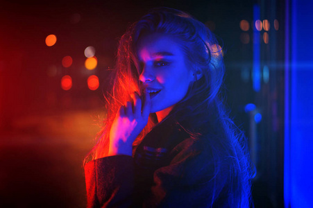 的年轻女性，在晚上市戏剧性霓虹灯背景构成