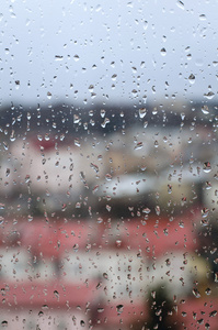 通过一个窗口与雨的城市景观滴眼液