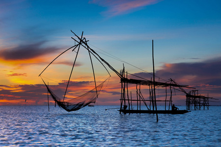 剪影渔夫在船上钓鱼的时候，泰国的行动湖中