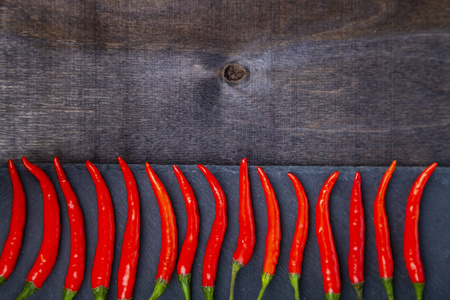 红辣椒是一个黑暗的背景。辣椒被分解成一排