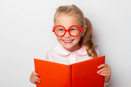 戴眼镜的小女孩抱着一本开放的书