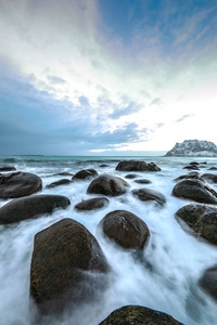 在晚上时冷挪威海海岸上的古代石头。罗弗敦群岛。美丽的挪威风景