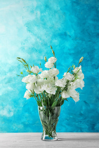 花瓶与美丽的洋花在桌子上对颜色背景
