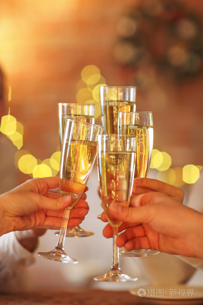 在金色的背景上的手中的香槟杯.聚会和庆祝的概念