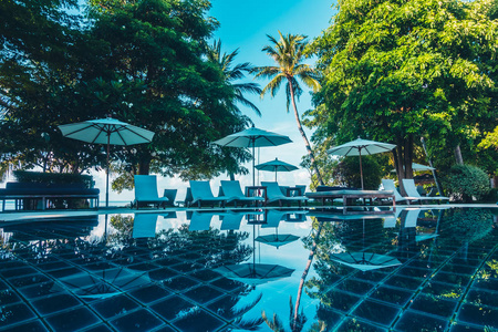 美丽的豪华室外游泳池, 带雨伞和椅子在酒店和度假胜地旅行