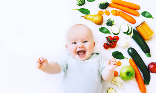 健康的儿童营养, 食物背景, 顶级视图。微笑的婴儿8月大, 周围有不同的新鲜水果和蔬菜在白色的背景。婴儿第一固体喂养