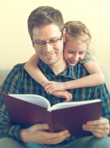 带着女儿在家里的父亲看书