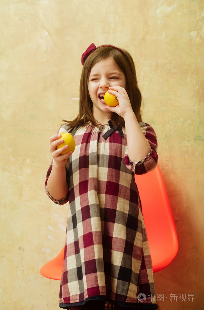 可爱的小女孩眨眼睛吃柠檬
