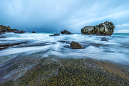 在晚上时冷挪威海海岸上的古代石头。罗弗敦群岛。美丽的挪威风景