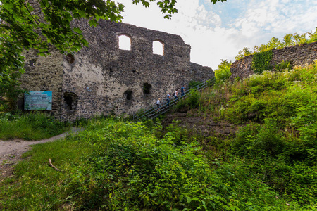 游客爬楼梯附近的古城堡的墙壁几乎被时间和天气破坏