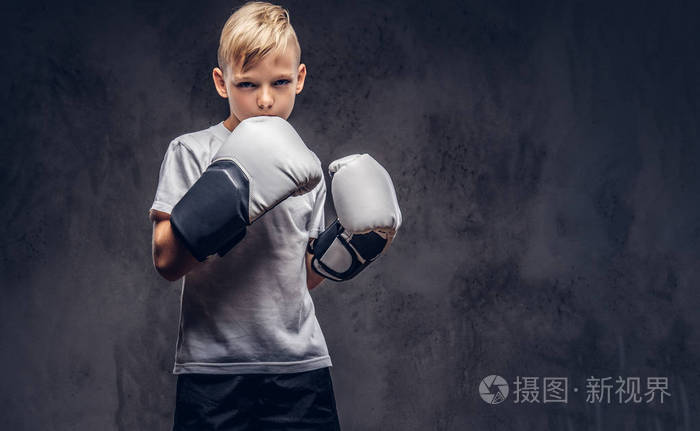 一个英俊的小男孩拳击手, 金发女郎身穿白色 t恤, 准备战斗.