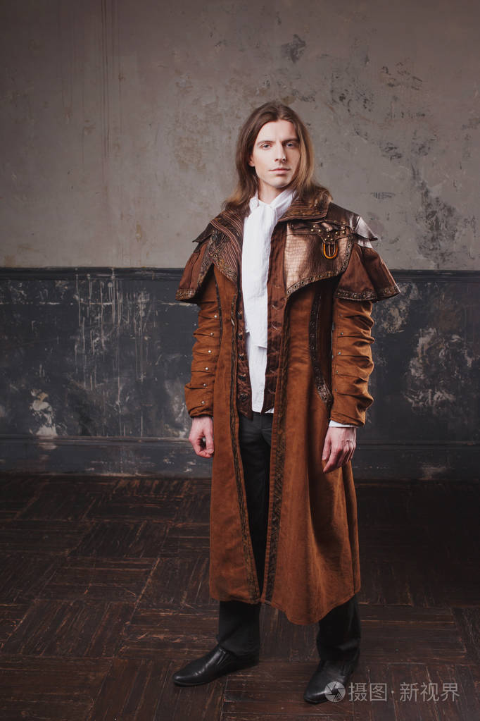在棕色的斗篷,蒸汽朋克风格的英俊男性.复古男人肖像 grunge 的背景