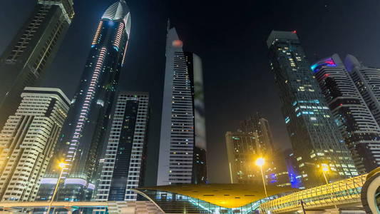 市中心的迪拜高塔夜游戏中时光倒流 hyperlapse。谢赫扎耶德路与摩天高楼的视图。交通道路和地铁线上。闪烁的灯和创新