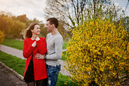恩爱夫妻拥抱附近布什与黄色的花照片