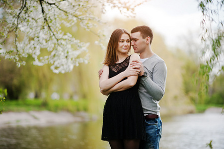 年轻夫妇花树爱户外背景湖中