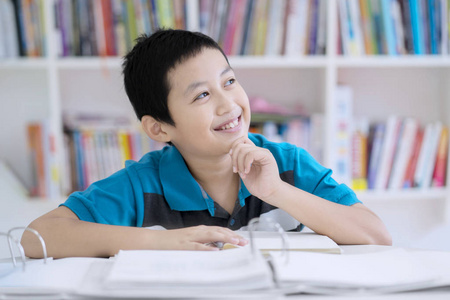 在图书馆学习中英俊青春期学生的形象沉思照片