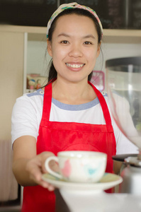 女店员拿着杯咖啡