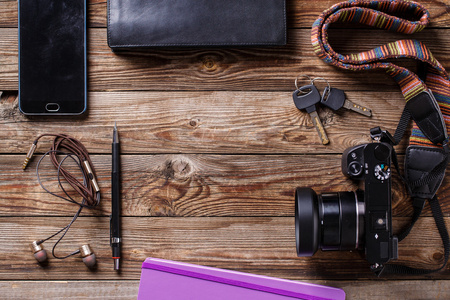 旅游概念耳机 摄像头 写生 钱包 铅笔和木制背景上的键