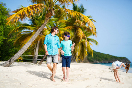 父亲和孩子们在热带岛屿上享受海滩度假