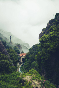 西班牙蒙特塞拉特修道院附近的山脉。云和雾。悬崖上的树。夏天假期在山里