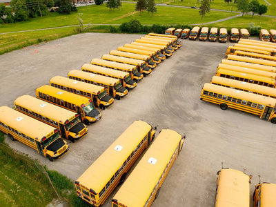 满是校车的停车场等着教育旺季。排满了许多 schoolbus 准备接学生上学。从上面的无人机鸟瞰图