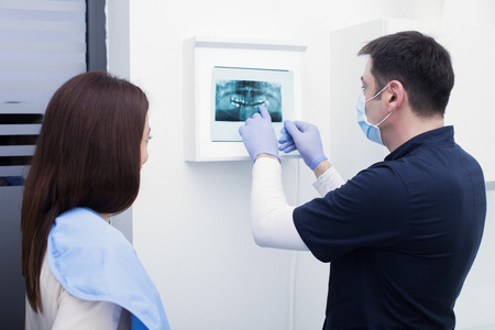 他在牙科诊所的病人显示 x 射线的男性牙医