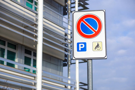 蓝色残障标志停车点, 残疾人停车许可证在电线杆上与便利店在加油站区域背景, 复制空间