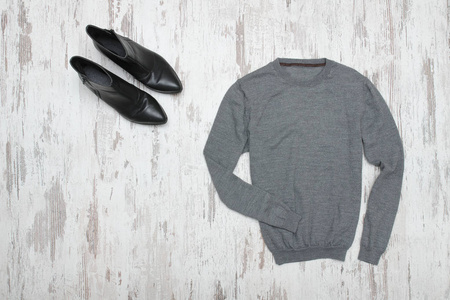 灰色的毛衣和黑色的鞋子。时尚理念