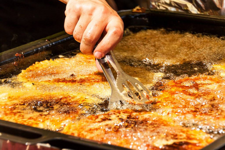 土豆煎饼放在平底锅里.传统膳食.油腻的食物.肥胖的危险照片
