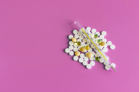 药片药物和温度计, whitetablets 胶囊在蓝色, 健康和医学概念。白色的医学药丸在粉红色的背景。复制空间