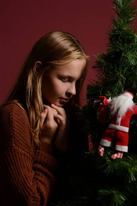 在白色壁炉旁边的女孩, 用玩具装饰圣诞树。
