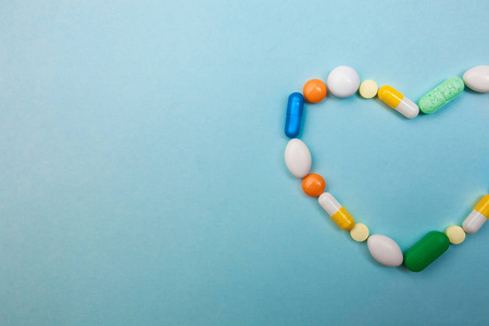 多色片和心形胶囊, 白瓶片, 医药药丸, 蓝色背景, 止痛药照片