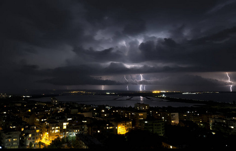 城市上空漆黑夜空中的壮观雷暴图片