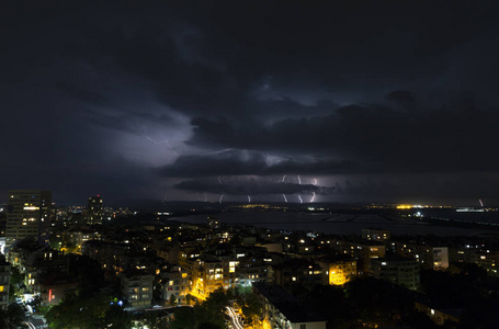 城市上空漆黑夜空中的壮观雷暴图片