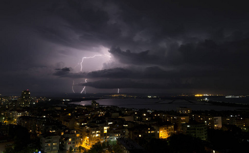 城市上空漆黑夜空中的壮观雷暴图片