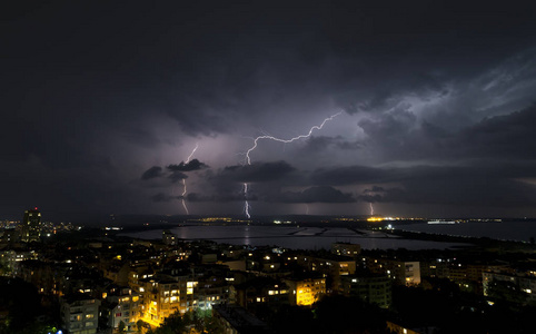 城市上空漆黑夜空中的壮观雷暴图片