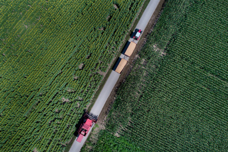 双挂车拖拉机空中图像与联合收割机在农村公路上的田间拍摄