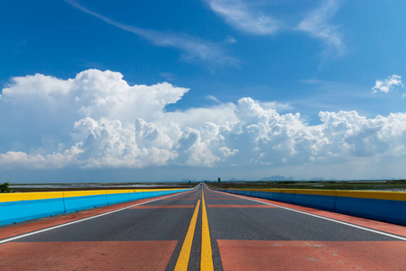 天空中的白云与空旷的道路和五颜六色的交通线