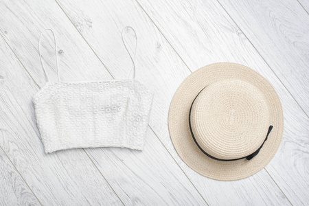 时尚的理念。女夏季衣柜。草帽和白色的顶部。顶部视图