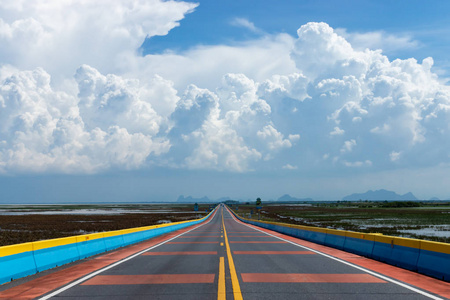 天空中的白云与空旷的道路和五颜六色的交通线