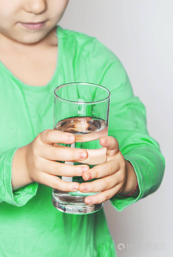 孩子他手里拿着一杯水.选择性的焦点