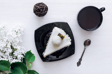 带榛子的海绵蛋糕, 奶酪椰子奶油, 天然奶油和果酱层的激情水果和杯热可可在白色木桌背景