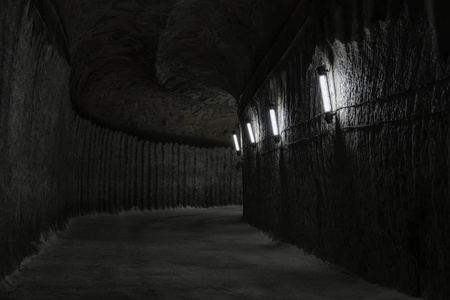 在盐矿的黑暗的地下走廊或隧道, 灯光昏暗的灯光照亮。美丽的黑暗地下背景