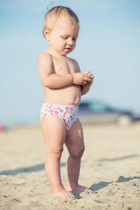 可爱的小宝贝在海边的沙滩上玩玩具