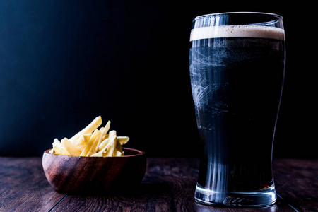 啤酒有零食薯片木制表面黑