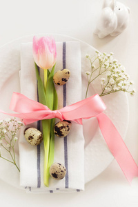 粉红丝带与白色背景上的郁金香优雅表设置。复活节的浪漫晚餐。顶视图