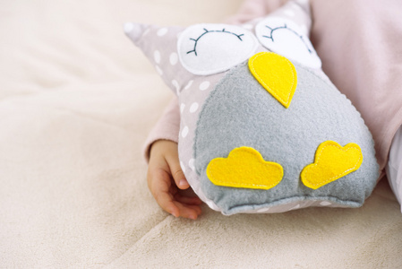 宝贝女孩拥抱猫头鹰玩具睡觉的时候
